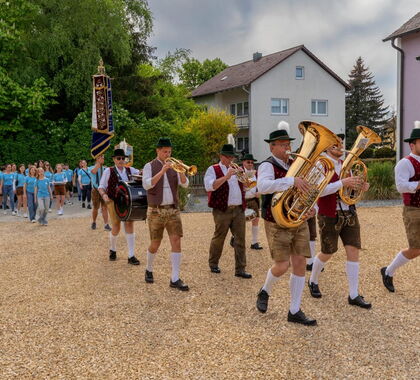 Spielende Musiker beim Einmarsch in Richtung Festzelt gefolgt vom Jubelverein